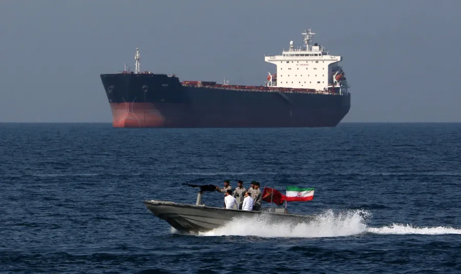 Iranian naval vessel passing a tanker in the Strait of Hormuz — rising geopolitical risk failed to sustain gold's safe-haven bid