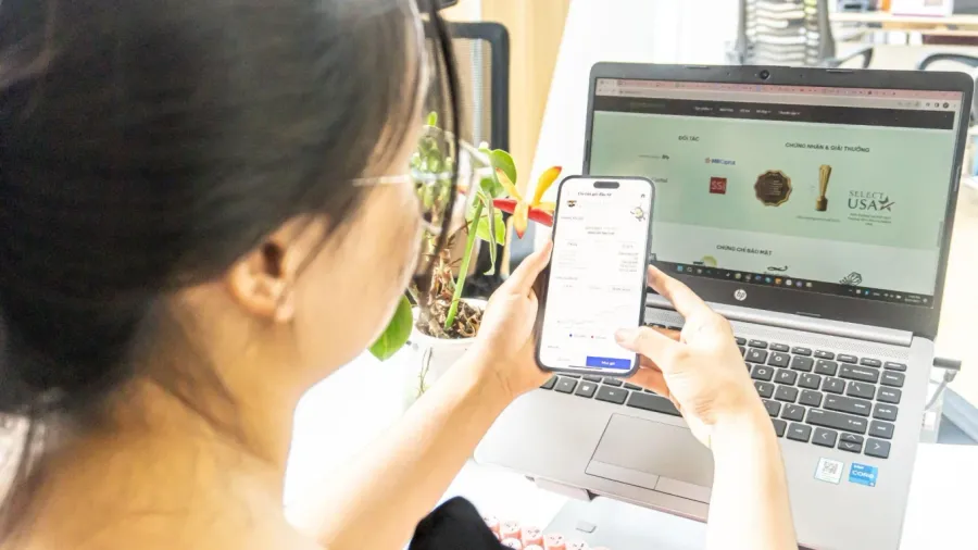 A young Vietnamese investor managing a fund portfolio on a mobile app