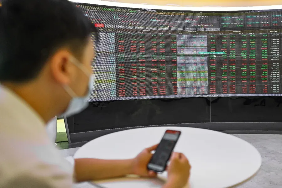 Retail investor watching both the board and a phone