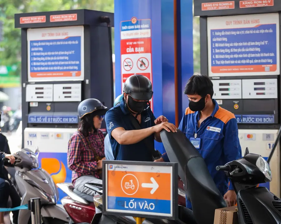 A gas station in Vietnam with a staff member fueling a customer's motorbike
