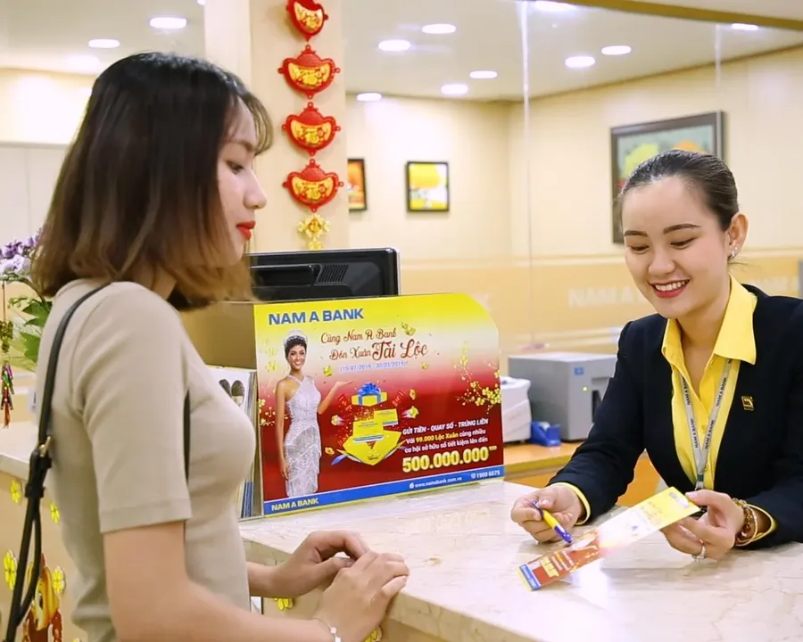 A bank teller processes a savings deposit for a customer
