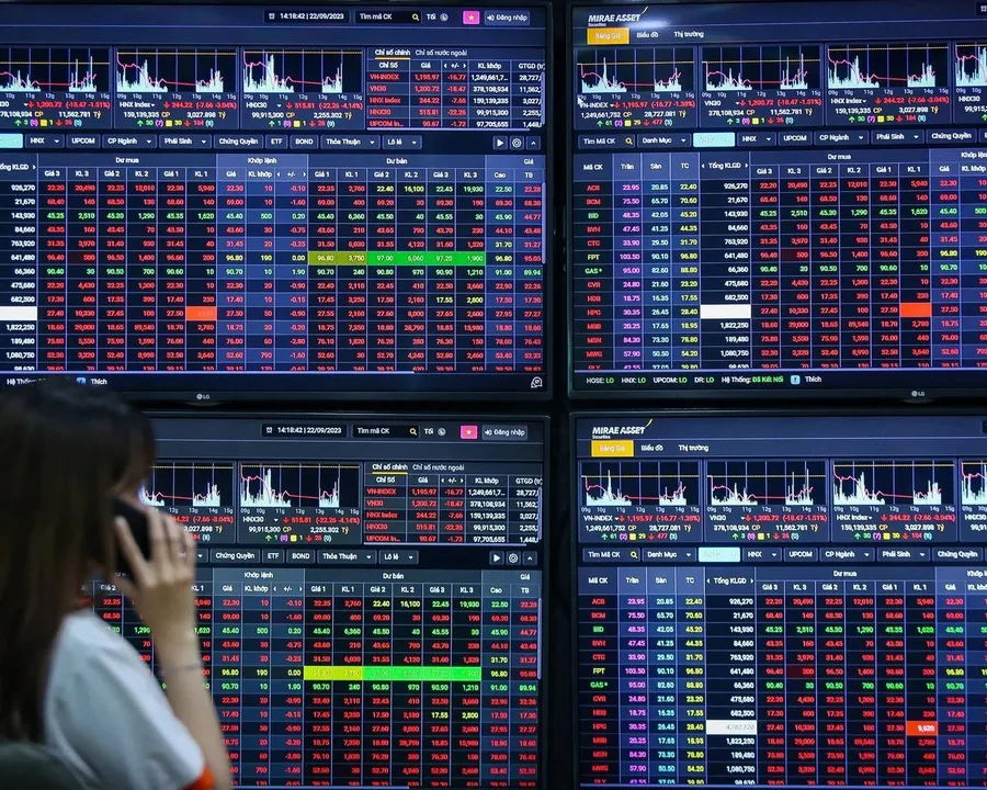 Investors watching a stock board across multiple screens, dominated by red