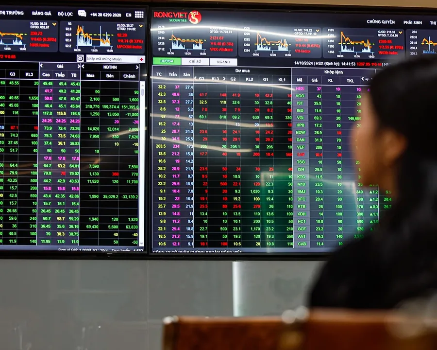 A retail investor watching stock price boards at a securities firm