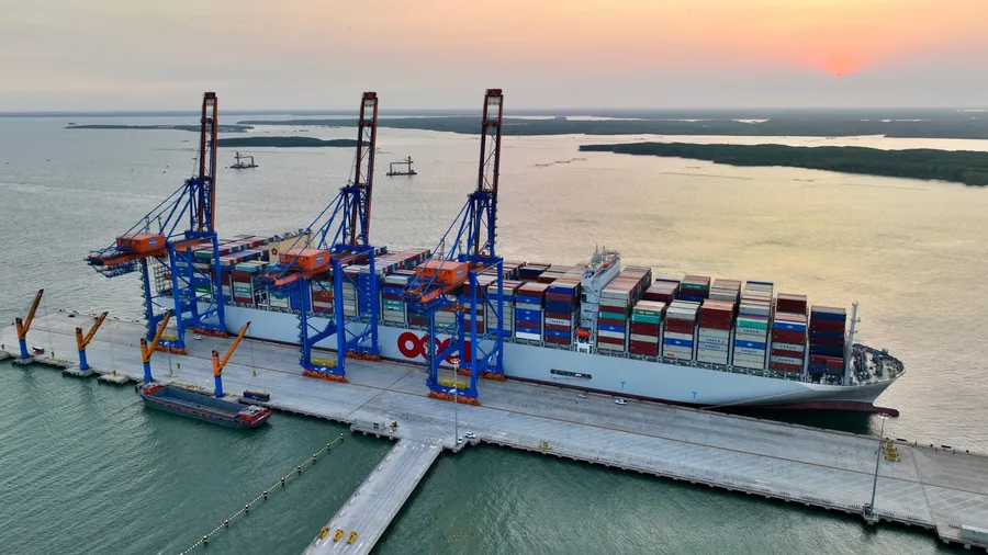 A large container ship berthed at a deep-water terminal with ship-to-shore cranes