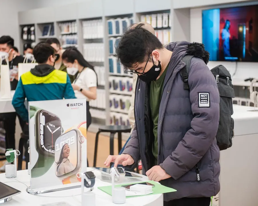 A shopper trying Apple products in a store