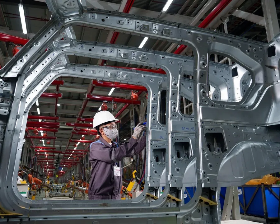 A worker inspects body frames on the VinFast assembly line