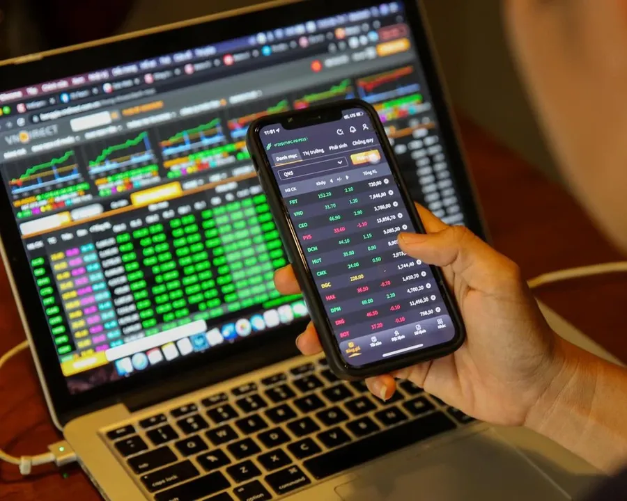 Investors watching stock prices on a laptop and phone