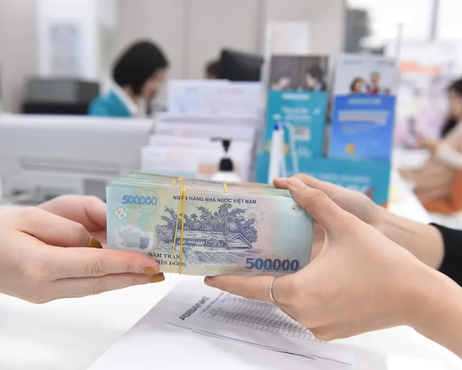 Sổ tiết kiệm ngân hàng đặt cạnh tiền mặt